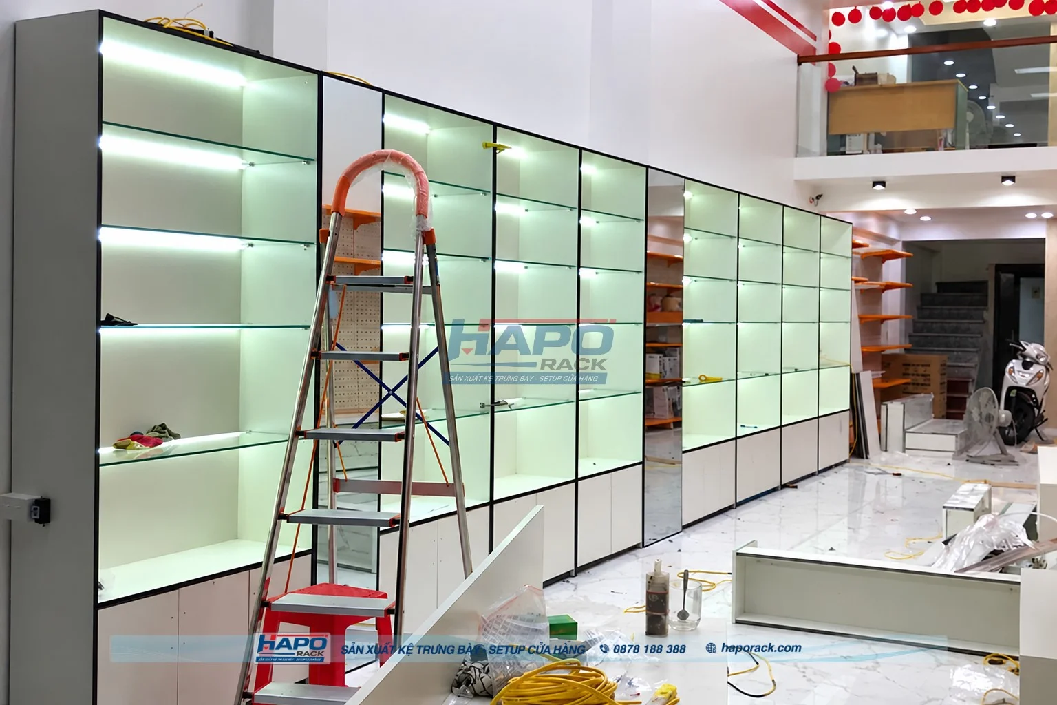 Kệ gỗ trưng bày sát tường có đèn LED giúp tối ưu không gian cửa hàng
